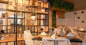 uma sala de jantar com mesas e cadeiras brancas em Hotel Ruittoque D Prada em Bucaramanga