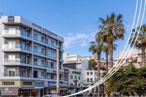 a building on a city street with palm trees at Raise Kornarou City Stay in Heraklio Town