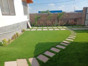 a garden with a lawn with stepping stones on it at Khushi Villa in Kakarmatha