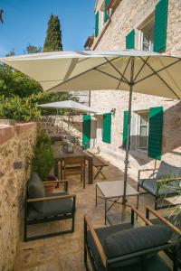 d'une terrasse avec des tables, des chaises et un parasol. dans l'établissement Revelin Hvar, à Stari Grad