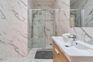 een witte badkamer met een douche en een wastafel bij Setubal Prime in Setúbal