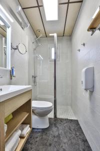 een badkamer met een toilet, een wastafel en een douche bij Hôtel-Restaurant Logis Europa in Maussac