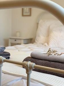 a bed with two towels on top of it at Woodview Cottage in Glamis