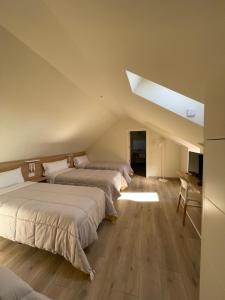 a room with two beds and a desk in a room at APARTAMENTOS TURÍSTICOS GUIANA in Ponferrada