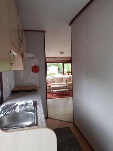 eine Küche mit einem Waschbecken und ein Wohnzimmer in der Unterkunft Beach Resort Kamperland - 771 in Kamperland