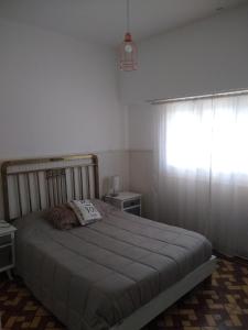 1 dormitorio con 1 cama grande y ventana en La Casa de Ischia en Mar del Plata