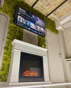 a fireplace with a tv above it in a house at Old Town Suite in Guardiagrele