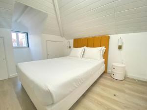 1 cama blanca grande en una habitación blanca en Vibrant Setúbal III, en Setúbal