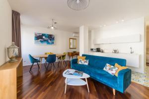 a living room with a blue couch and a table at Castalia Apartments & Rooms Duomo Taormina in Taormina