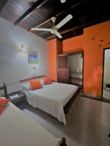 a bedroom with two beds and a ceiling fan at Hotel Nueva Granada in Santa Marta