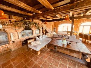 a living room with a couch and a brick wall at Villa Goričko in Šalovci