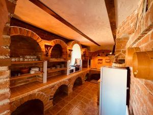 a kitchen with a refrigerator and a brick wall at Villa Goričko in Šalovci