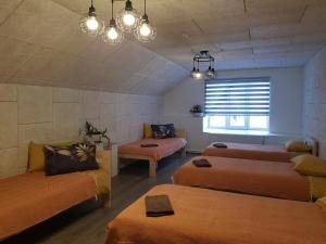 Habitación con 3 camas y sofá en Viesu māja Vālodzes en Mārkalne