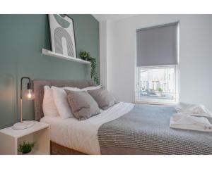 a bedroom with a large bed with a window at Central Belfast Apartments Eden in Belfast