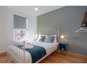 een slaapkamer met een wit bed en een raam bij Central Belfast Apartments Eden in Belfast