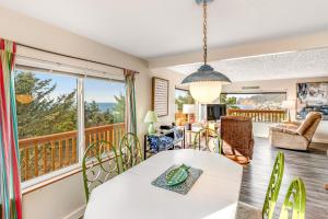 a living room with a table and chairs and a balcony at Whale Watch in Lincoln City