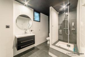 La salle de bains est pourvue d'une douche, d'un lavabo et d'un miroir. dans l'établissement Hotel Restaurant au Floridor, à Thann