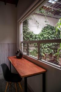 uma mesa de madeira e uma cadeira ao lado de uma janela em CASA DE LOLA em Medellín
