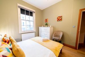 a bedroom with a bed and a window and a chair at [St.Paul's Cathedral] Modern Apartment City of London in London