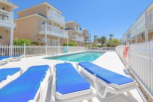 a swimming pool with two lounge chairs next to a building at * Sugar Sands * Steps to Beach * Pool * Balconies * in Panama City Beach