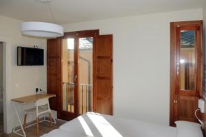 a bedroom with a bed and a table and a desk at APARTAMENTOS TURÍSTICOS GUIANA in Ponferrada