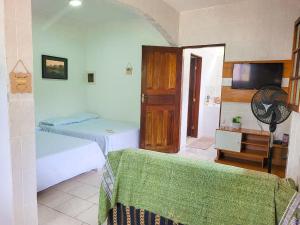 a bedroom with two beds and a tv in it at Herdeiros do Pai in Paraty