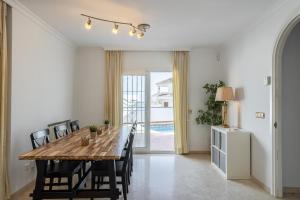 a dining room with a wooden table and chairs at Casa Isabella luxury villa in Nerja
