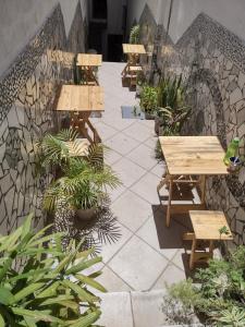 um pátio com mesas, bancos e plantas em Pousada Trilha do Pelo em Salvador