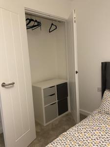 a bedroom with a closet with a bed and a door at Escape Homes in Barking