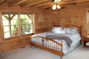 sypialnia z łóżkiem w drewnianym domku w obiekcie Robin Hill w mieście Georgetown