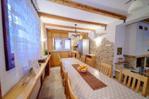 a kitchen and dining room with a table and chairs at Vila LALUKO in Zlatibor