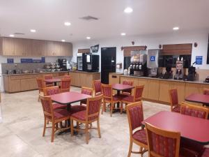 a restaurant with tables and chairs and a kitchen at Travelodge by Wyndham Florida City/Homestead/Everglades in Florida City