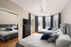 1 Schlafzimmer mit 2 Betten und einem Spiegel in der Unterkunft Majestic Retreat in the Laurentians in Morin Heights