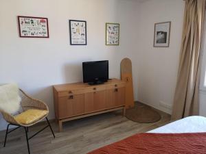 a bedroom with a tv on a dresser and a bed at T3 VUE MER A 20 mètres de la PLAGE ANGLET BIARRITZ in Anglet