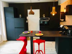 a kitchen with a table and two red stools at T3 VUE MER A 20 mètres de la PLAGE ANGLET BIARRITZ in Anglet