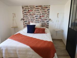 a bedroom with a bed with red and blue pillows at T3 VUE MER A 20 mètres de la PLAGE ANGLET BIARRITZ in Anglet