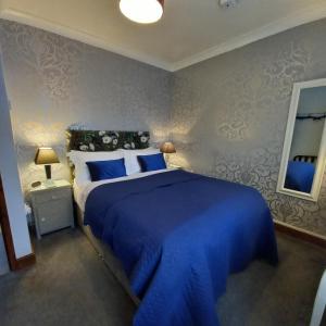a bedroom with a large blue bed with blue sheets at Middlethorpe Apartment in York