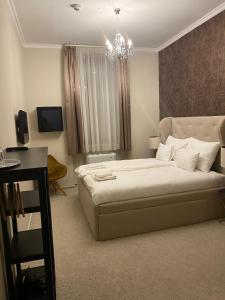 a bedroom with a bed and a chandelier at Váralja Home in Budapest