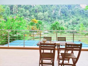 a table and chairs on a patio with a tennis court at Ipoh All Suite Resort, Jalan Haven Ipoh in Ipoh