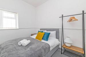 a bedroom with a bed with pillows and a window at 2 Bed Holiday House within Walton Area, Liverpool in Liverpool