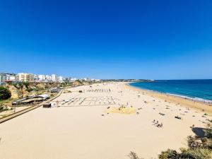 vista su una spiaggia con persone e sull'oceano di Apartment Praia Rocha Candimar Confort a Portimão