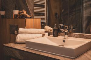 a bathroom with a sink and a mirror and towels at Apartamenty MonteVerde w Świeradowie-Zdroju in Świeradów-Zdrój