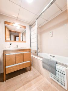 bagno con lavandino, vasca e specchio di Apartamento Acogedor en Avenida Juan Carlos 1º a Murcia