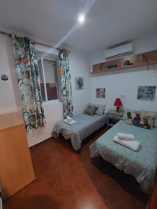 a bedroom with two beds and a window at APARTAMENTO SANTA MARÍA in Cádiz