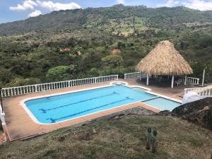 een leeg zwembad met een rieten dak bij Casa La Felisa hospedaje campestre Pandi cundinamarca in Pandi