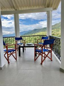 een veranda met stoelen en een tafel en uitzicht op de bergen bij Casa La Felisa hospedaje campestre Pandi cundinamarca in Pandi