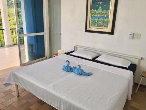 een slaapkamer met een bed met blauwe handdoeken bij Casa La Felisa hospedaje campestre Pandi cundinamarca in Pandi