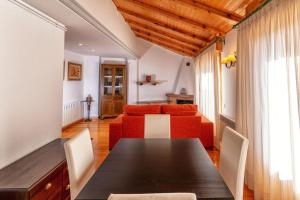 comedor con mesa y sofá rojo en Apartamento Los 3 Reyes, en Valderrobres