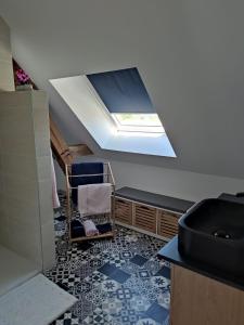 a room with a skylight and a bathroom with a sink at Chambre d'hôtes in Beaumont-Pied-de-Boeuf