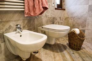 a bathroom with a white toilet and a sink at Casa Salvia in Garda
